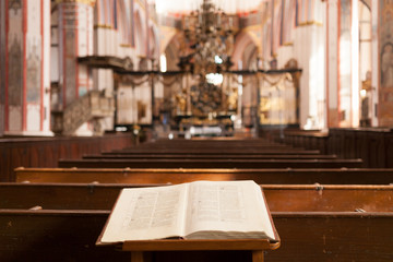 Bible around benches against the background of the altar in the Catholic church in germany