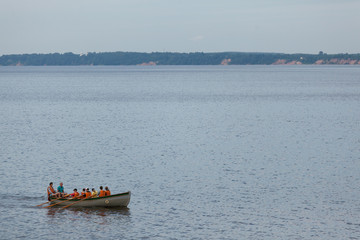 Rowers in lifejackets on a boat sail along the Gorky water reservoir on the Volga River