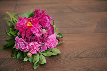  Beautiful pink bouquet of peonies on a wooden background.