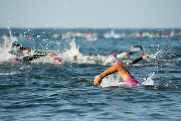 Group people in wetsuit swimming at triathlon