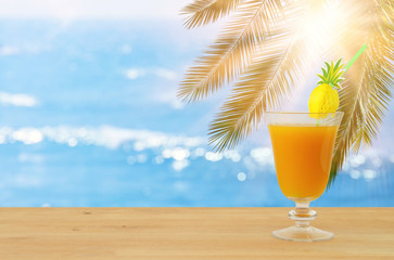 image of tropical and exotic fruit coctail over wooden table infront of sea landscape background.