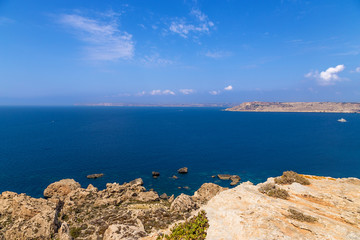 Fototapeta na wymiar Mellieha, Malta. Rocky northwest coast and the island of Gozo on the horizon