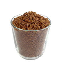 Transparent glass cup filled with instant coffee granules isolated on white background