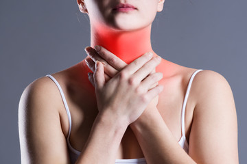 Sore throat, woman with pain in neck, gray background