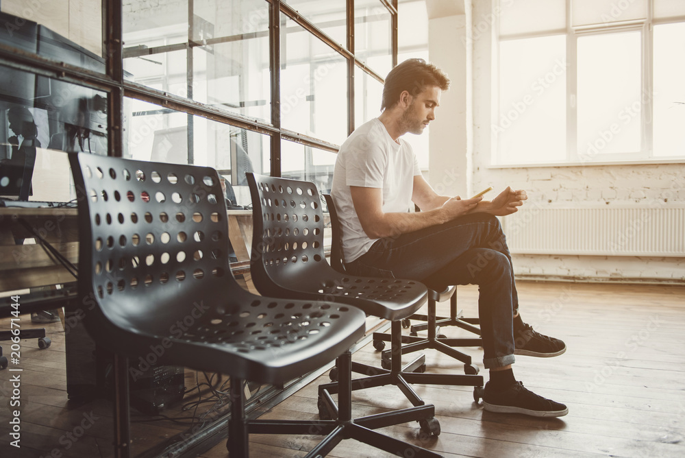 Aufkleber full length side view serene man typing in mobile while resting on chair inside