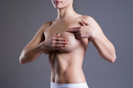 Woman examining her breasts for cancer, pain on female body