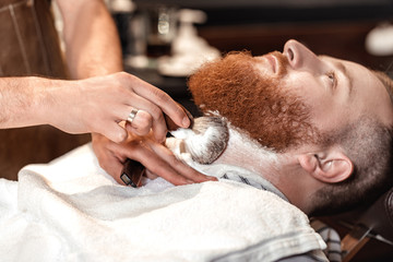 Obraz na płótnie Canvas Barber and bearded man in barber shop