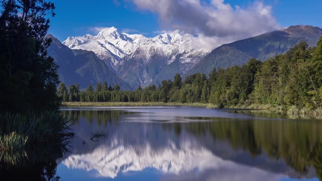 Time lapse of clouds moving over Mount. Cook and Mount. Tasman from Lake Matheson, New Zealand