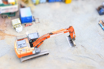 Digger excavator construction building site view from above miniature rubber tracks orange vehicle in operation excavating 