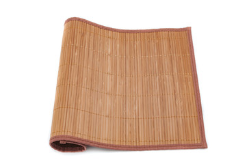 A bamboo mat on a white background is tucked on one side. Isolated.