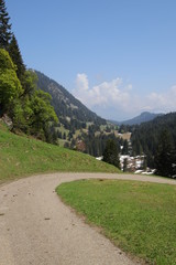 Fototapeta na wymiar Kurve eines Fahrwegs mit Bergpanorama