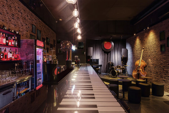 Modern jazz bar interior design, stage with black piano and cello, lamps above bar counter