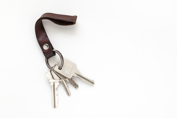 Keys attached to leather keychain on white background