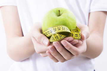 hand with tape measure and fruit, diet concept and healthy eating