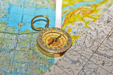 Compass laying on a topographic map.