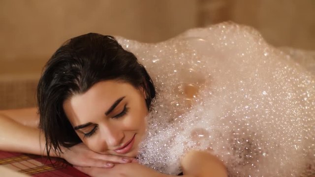 Woman covering by foam in hammam