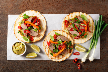 Mexican tacos with roasted  duck  meat, vegetables and green onion. Top view