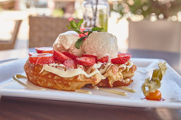 waffles with white chocolate sauce, ice cream and strawberries