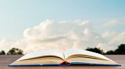 Open book against the sky with clouds