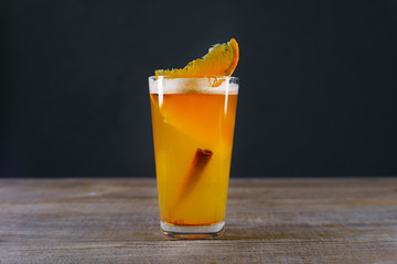 Hot apple cider with orange and cinnamon sticks in glass. Delicious holiday drink, warming...