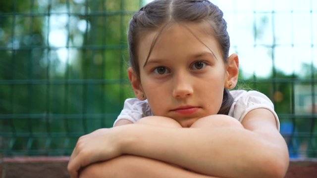 Closeup portrait of beautiful young girl. lonely bored and tired teen relaxing after roller skating in park outdoor