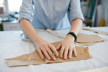 Fototapeta na wymiar Female Tailor Making Sewing Patterns On Table