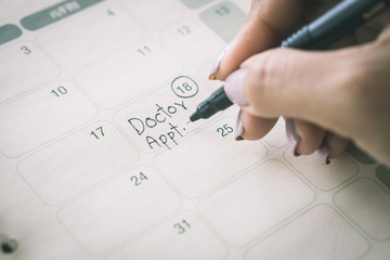 hand writing remind note on calendar for doctor appointment 