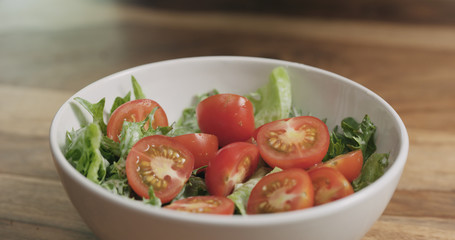 closeup adding tomatoes to caesar salad