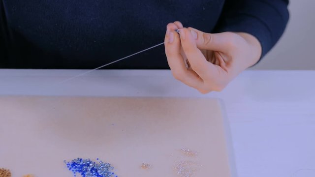 Professional jewelry designer making handmade eardrop with beads in studio, workshop. Fashion, creativity and handmade concept