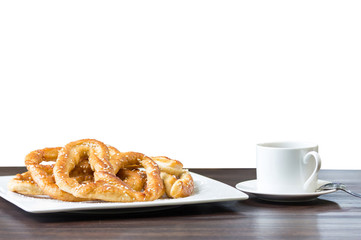 Sweet Pretzel bread on white plate and a cup of coffee.