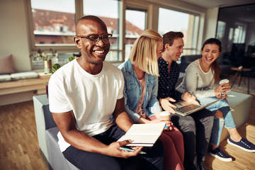 Smiling African businessman sitting with colleagues in a modern