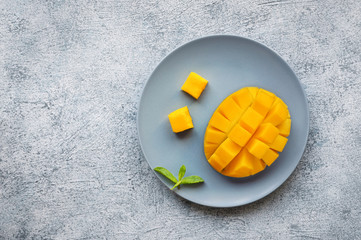 Sliced ripe mango fruit on concrete background. Top view. Copy space. 