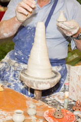 Fototapeta premium Craftsman making vase ceramic pot from fresh wet clay on pottery wheel
