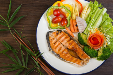 Grilled Salmon with mixed vegetables on wooden background