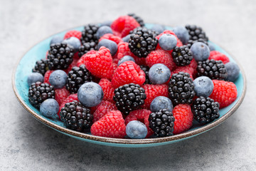 Fresh raspberries in a plate on a  vintage background.