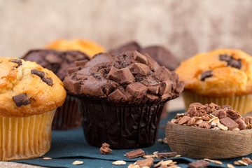 Homemade muffins with chocolate, vintage background.