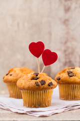 Homemade chocolate muffins with heart, vintage background.