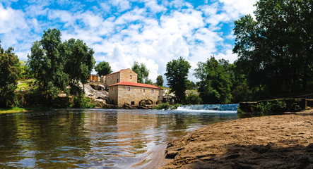 Panoramic view of the river Coura and a water mill. River beach of Vilar de Mouros, Portugal