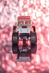 Bigfoot toy car color white, Car radio controller, background red BOKEH