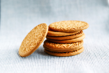 A round delicious yellow cookie lays a pile on the table