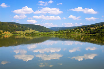 Fototapeta na wymiar Beautiful blue cloudy sky reflected in the lake