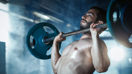 Close-up of a Muscular Shirtless Man Lifting Heavy Barbell and Doing Military Press Bodybuilding Exercise in the Industrial Gym Building.