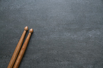 Drum stick on black table background, top view, music concept