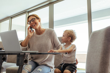 Busy woman with son in home office