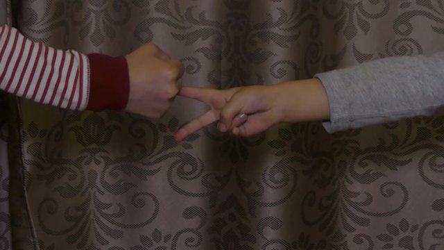Boy and girl play rock paper scissors