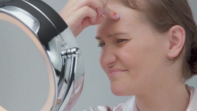 young woman disappointed about her first eye wrinkles