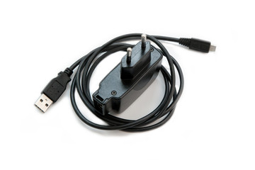 Black power adapter with USB cable for smartphones on a white background.