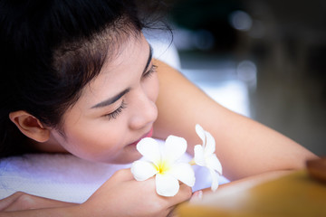 Portrait of beautiful asian people with close up view and close up eyes and smelling a flower. Beauty, healthy, spa and relaxation concept.