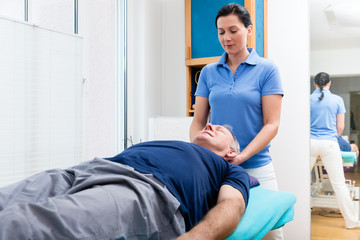 Fototapeta premium Elderly man getting massage from physio