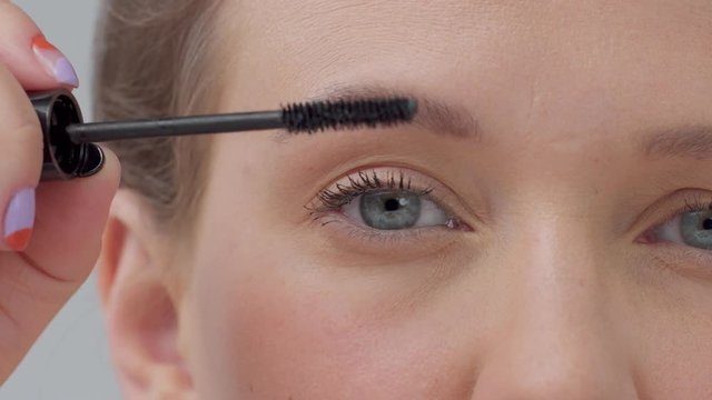 closeup macro of woman's eye put maskara on lashes
